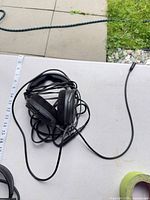 Headphones coiled with cable and adapter on table next to ruler