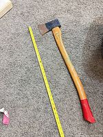 Full view of axe beside measuring tape