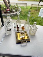 All items displayed on table: three decanters, whisky tag, brass tray with inkwell