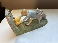 Angled view of entire resin bookend showing Christopher Robin pulling Winnie the Pooh through hole with Rabbit behind