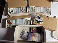 Four containers filled with sorted Ty Beanie Babies trading cards, visible character cards Jasper, Chip, Blackie on top