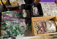 Overview of multiple bags and bins filled with cabinet knobs and pulls