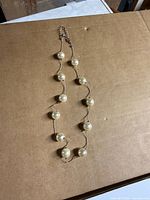 Full view of necklace displaying faux pearls and gold-tone chain