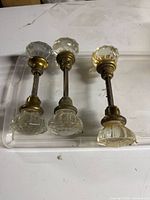 Three glass and brass door knob sets aligned top view