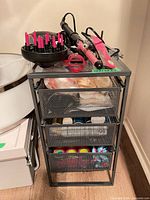 Overview of hair-styling electronics and accessories on mesh drawers (cart not included)