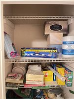 Overall shelf view with napkins, plates, straws, plastic wrap, cling film, garbage bags
