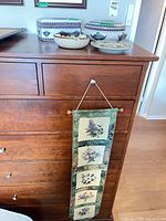 Entire lot on dresser top showing box, bowl, two plates, hanging tapestry
