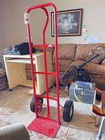 Full front view of red steel hand truck showing frame and wheels