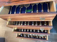 Three drawers showing organized flatware set