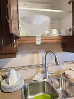 Upper cabinet with frosted glass bowl, cups and saucers visible