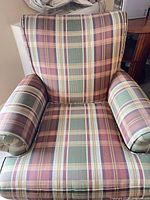 Front view of plaid swivel armchair showing overall design and upholstery