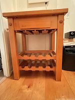 Front view of cart showing drawer and two slatted wine shelves