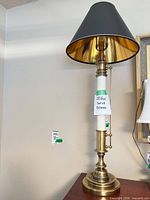 Full view of brass table lamp with black shade