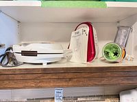 Shelf view showing waffle maker, T-fal slicer/shredder body, chute and discs