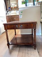 Front angled view showing overall table, drawer closed, lower shelf and turned legs