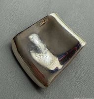 Front view showing concave square shape and polished surface