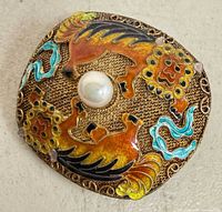 Front view showing cloisonné enamel design and central pearl