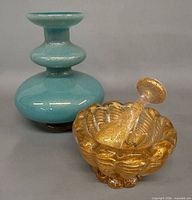 Amber gold-flecked mortar and pestle beside turquoise vase