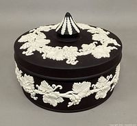 Front view of lidded bowl showing grapevine relief and finial