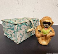 figurine beside closed brocade box
