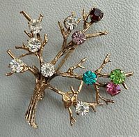 Front view of brooch showing multicolor rhinestones and tree design