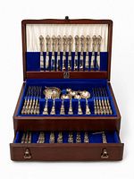 Open chest displaying two tiers of flatware showing knives, forks, spoons, serving pieces