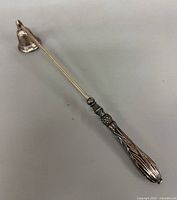 Full view candle snuffer showing length and design