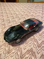 Front left view of black 1:24 Corvette model showing red interior and body condition