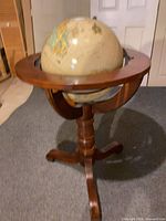 Full view of globe in wooden stand showing overall construction and finish