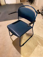 Front angled view of blue cantilever chair showing seat, back, armrests and sled base