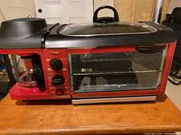 Front view of breakfast station showing toaster oven window, dials, coffee maker and griddle lid