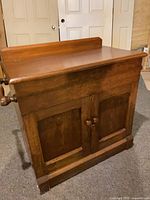Front view showing distressed finish, paneled doors, backsplash