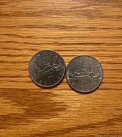Reverse sides of 1969 and 1982 Canadian $1 coins showing canoe design and dates