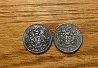 Reverse sides showing Canadian Coat of Arms and denomination on both coins
