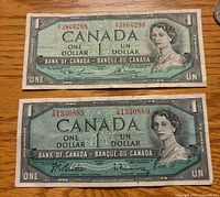 Fronts of two 1954 Canada one-dollar notes showing serials and portrait