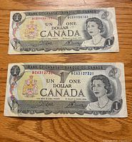 Fronts of both 1973 Canadian $1 notes showing Queen Elizabeth II portrait and serial numbers