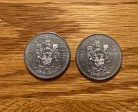 Both sides of two 1985 Canadian 50¢ coins showing reverse design