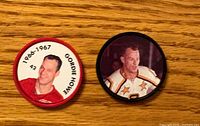Front view of both Gordie Howe hockey coins showing portraits and rim colours