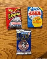 front of three sealed baseball card packs showing designs and branding