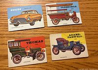 Fronts of four 1954 Topps World on Wheels cards on wood surface