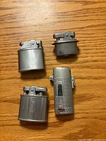 Front view of four silver-tone metal lighters