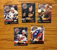 Fronts of the five Duracell Pinnacle Power Check cards laid out on wood surface