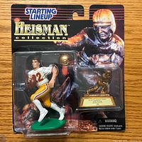 Front view of sealed Starting Lineup Heisman Collection Doug Flutie figure and Heisman Trophy accessory on card backing