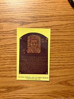Front of Willie Mays Hall of Fame plaque postcard showing plaque image and yellow border
