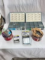 Overall lot showing two compartment boxes, two coffee tins, blister packs and nail case