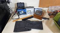 Overview of both Garmin GPS units, boxes, power cable, mount, brush, pouches, wooden box