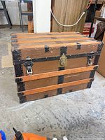 Front view showing canvas body, wooden slats, brass latch, metal hasps