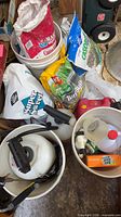 Overview of buckets with sprayers, fertilizer bags, gas can, cleaner