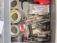 Drawer view showing tapes, hardware, snips, screwdrivers, lighters, pump