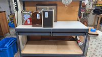 Full front view of workbench showing frame, top, pegboard, lower shelf, drawer rails, fan, hooks